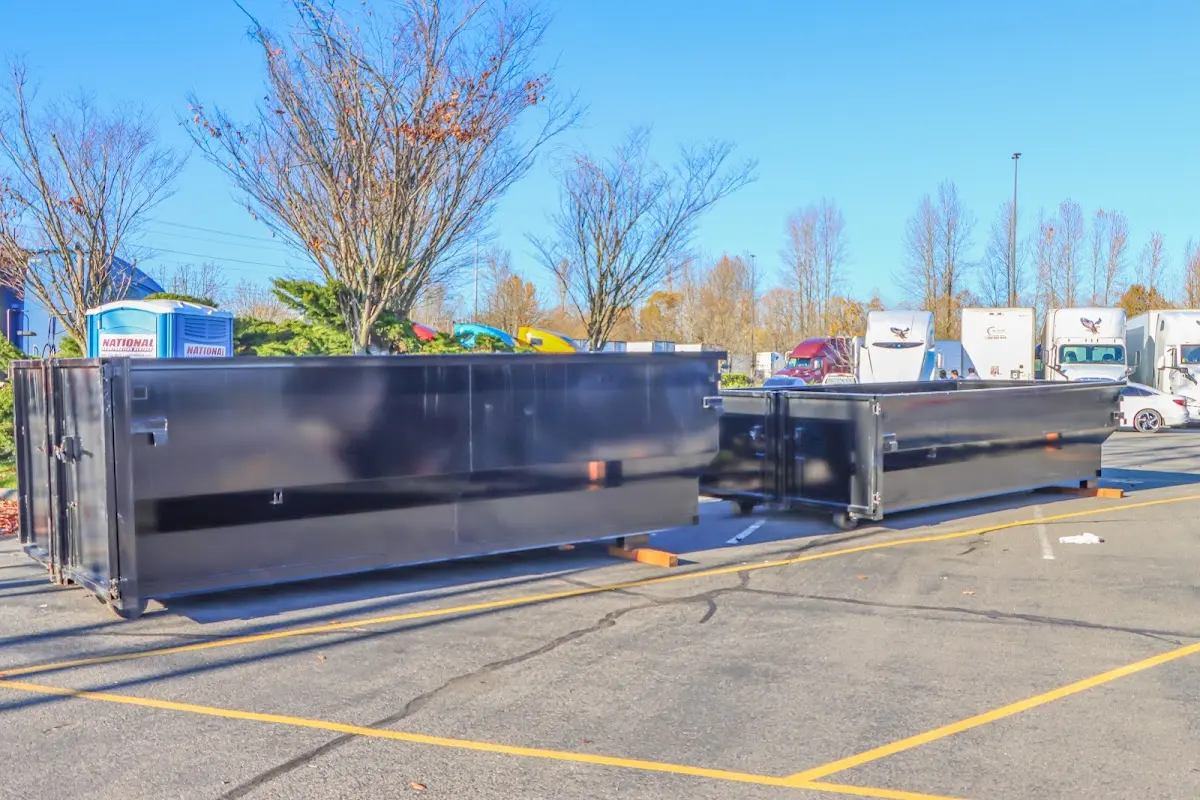 Professional dumpster rental service with roll-off container on residential driveway in Whitehall